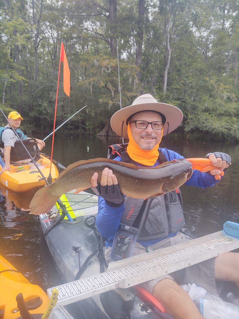 Kayak angler displays bowfin